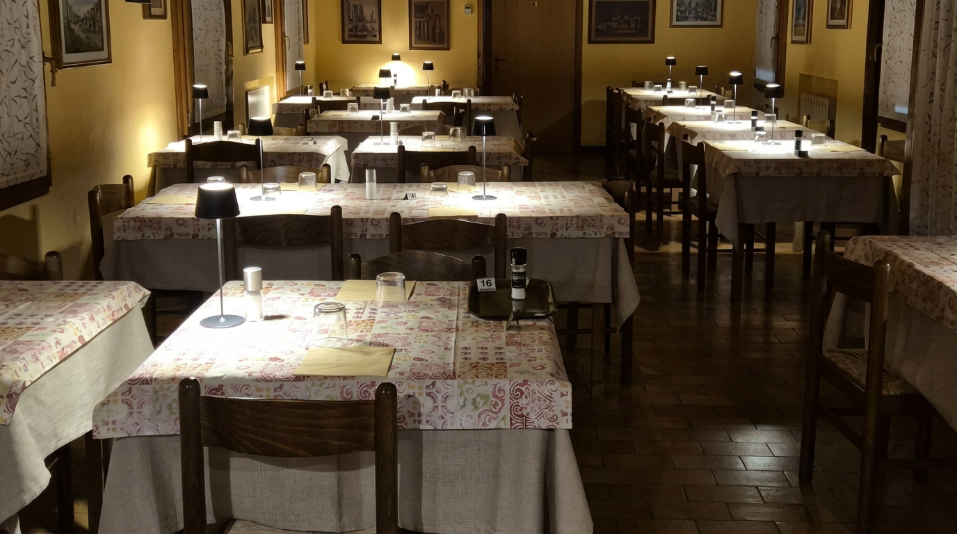 I tavoli della sala apparecchiati per la cena, con le lampade da tavolo